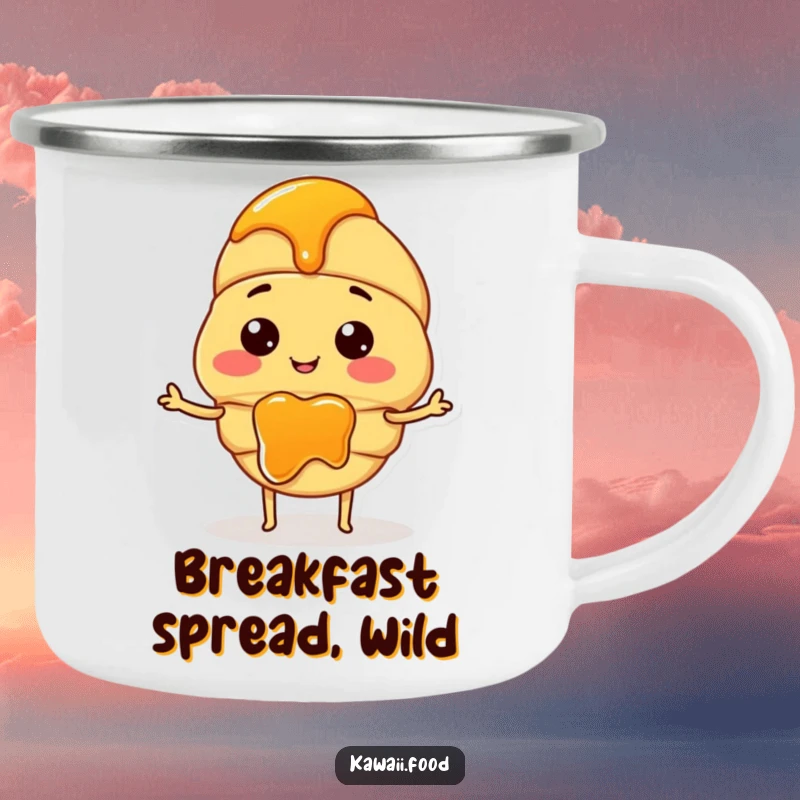 Funny camping mug with a smiling croissant character and tiny arms, spreading jam during an outdoor adventure.